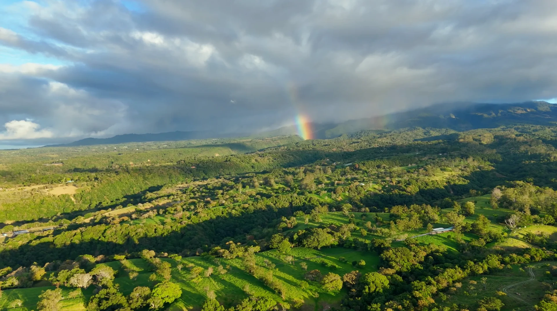 Aerial view of the green Boquete highlands with a rainbow over the mountains